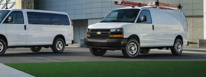 Chevrolet Express Cargo Van with a roof ladder rack at a commercial building