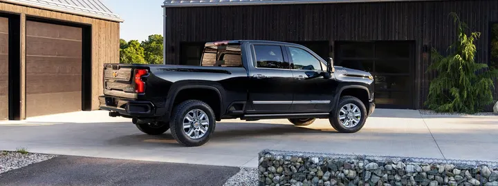 Chevrolet Silverado 3500 HD crew cab parked beside a timber outbuilding