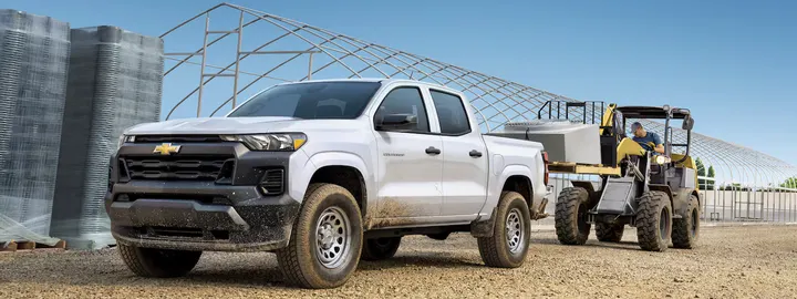 Chevrolet Colorado WT crew cab at a construction site with a compact loader