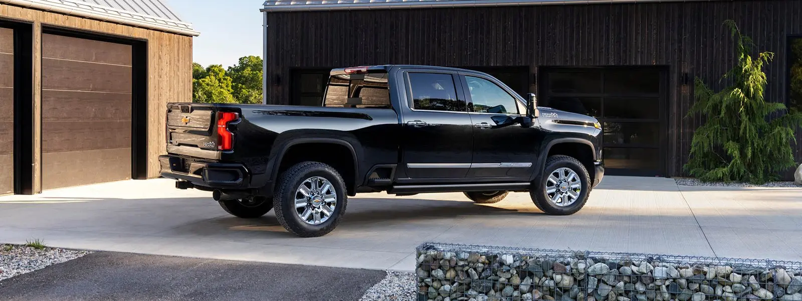 Chevrolet Silverado 3500 HD crew cab parked beside a timber outbuilding