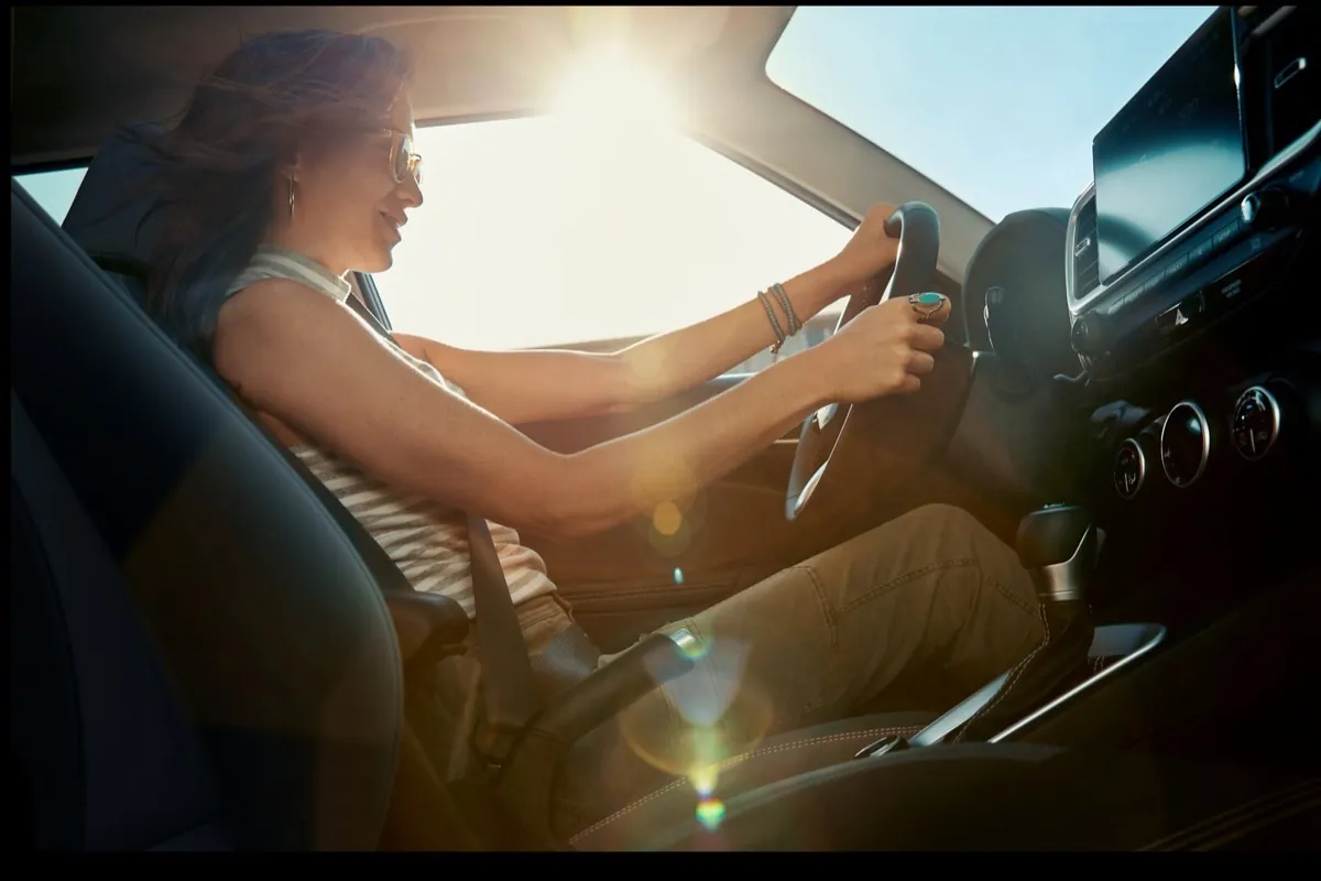 Woman driving a 2026 Hyundai Venue in the sunshine